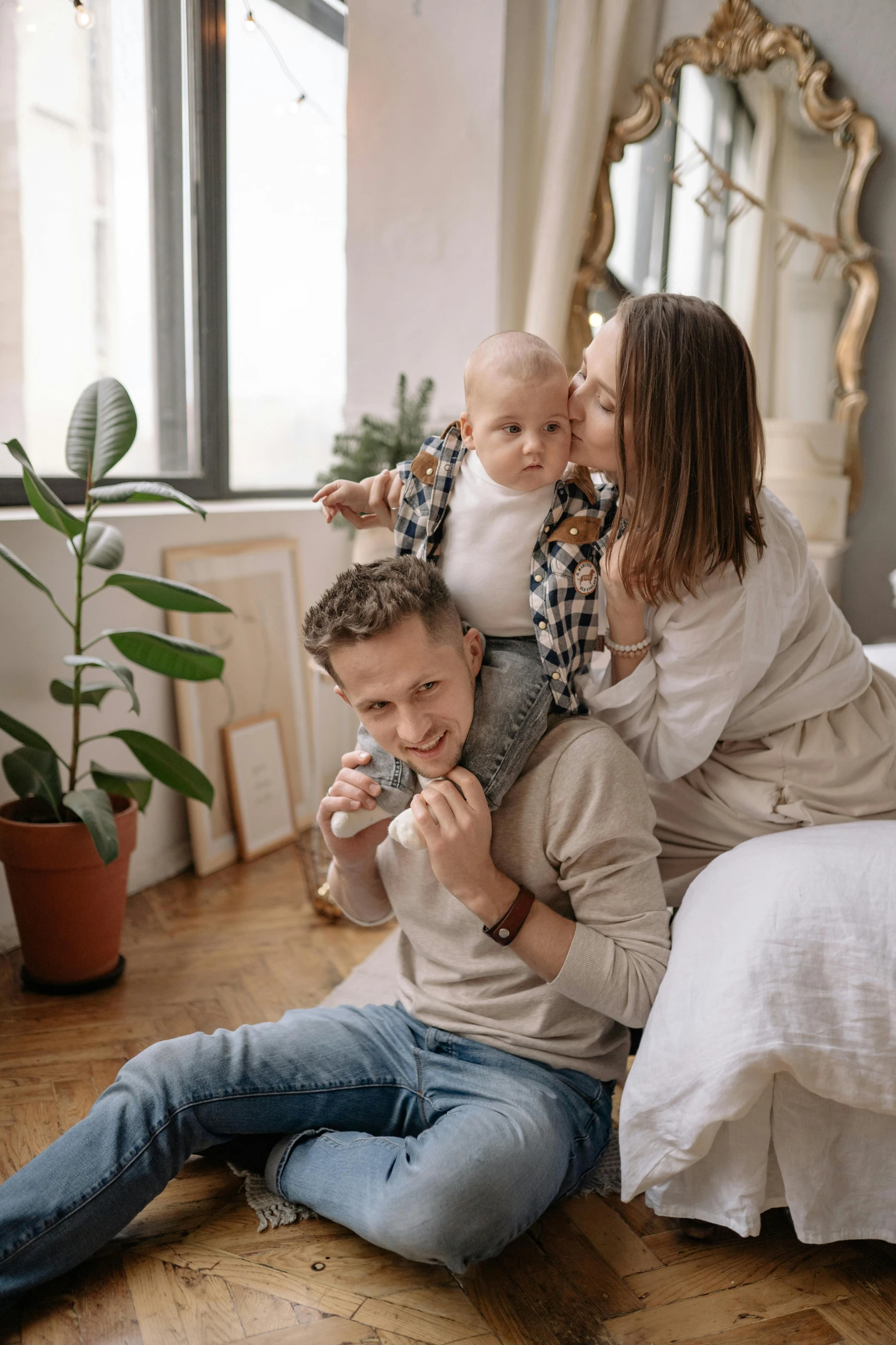 a man and woman sitting on the floor with a baby, sitting on the bed, plants, profile image, licking out