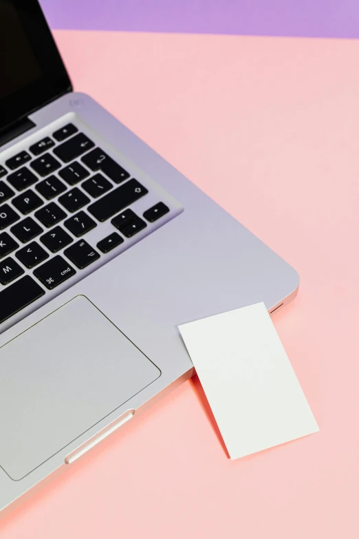 a laptop computer sitting on top of a pink and purple surface, business card, white paper, promo image, 9 9 designs