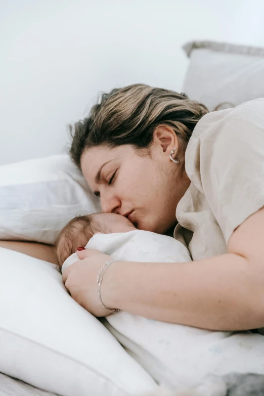 a woman laying in bed with a baby, pexels contest winner, romanticism, profile image, hugging each other, tiny mouth, manuka