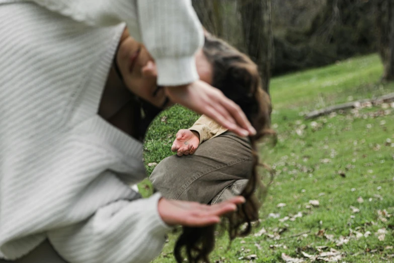 a woman standing on top of a lush green field, a picture, by Emma Andijewska, pexels contest winner, renaissance, man grabbing a womans waist, falling out of the face, woman with braided brown hair, at a park