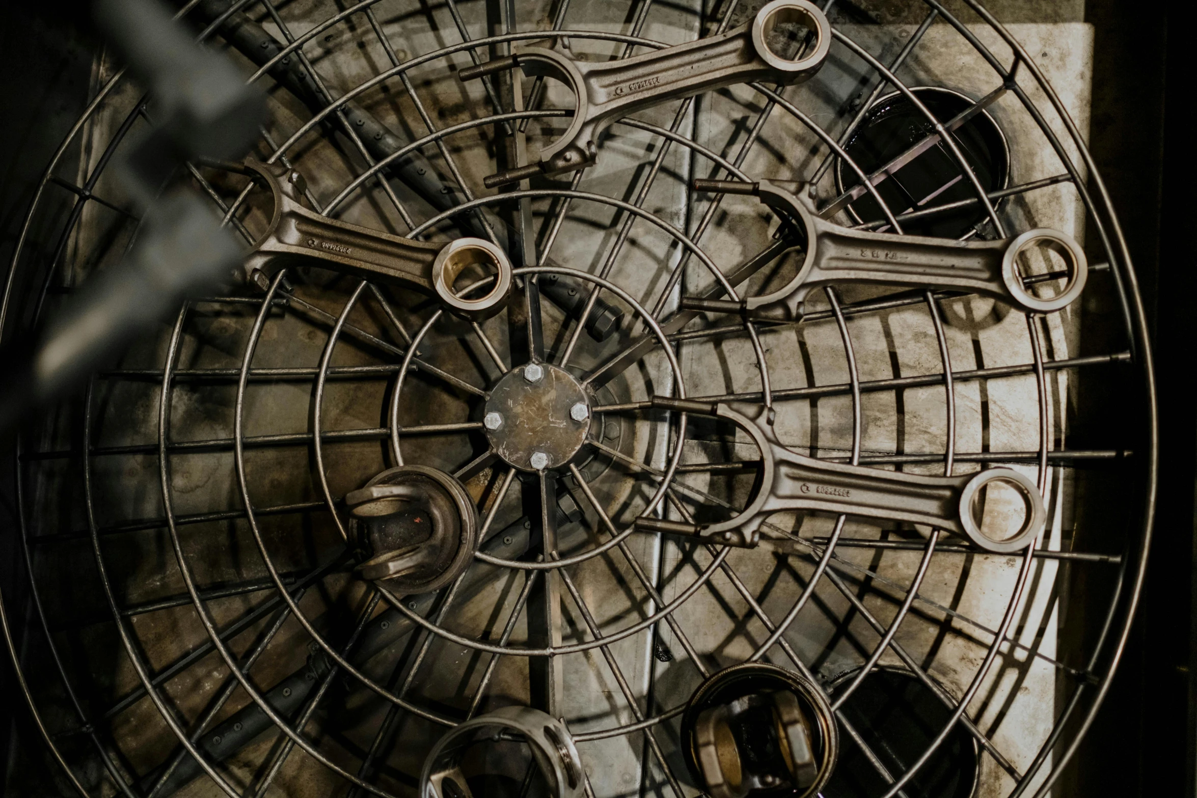 a large metal clock sitting inside of a building, by Konrad Witz, pexels contest winner, kinetic art, spirals tubes roots, dungeon background, looking down from above, cages