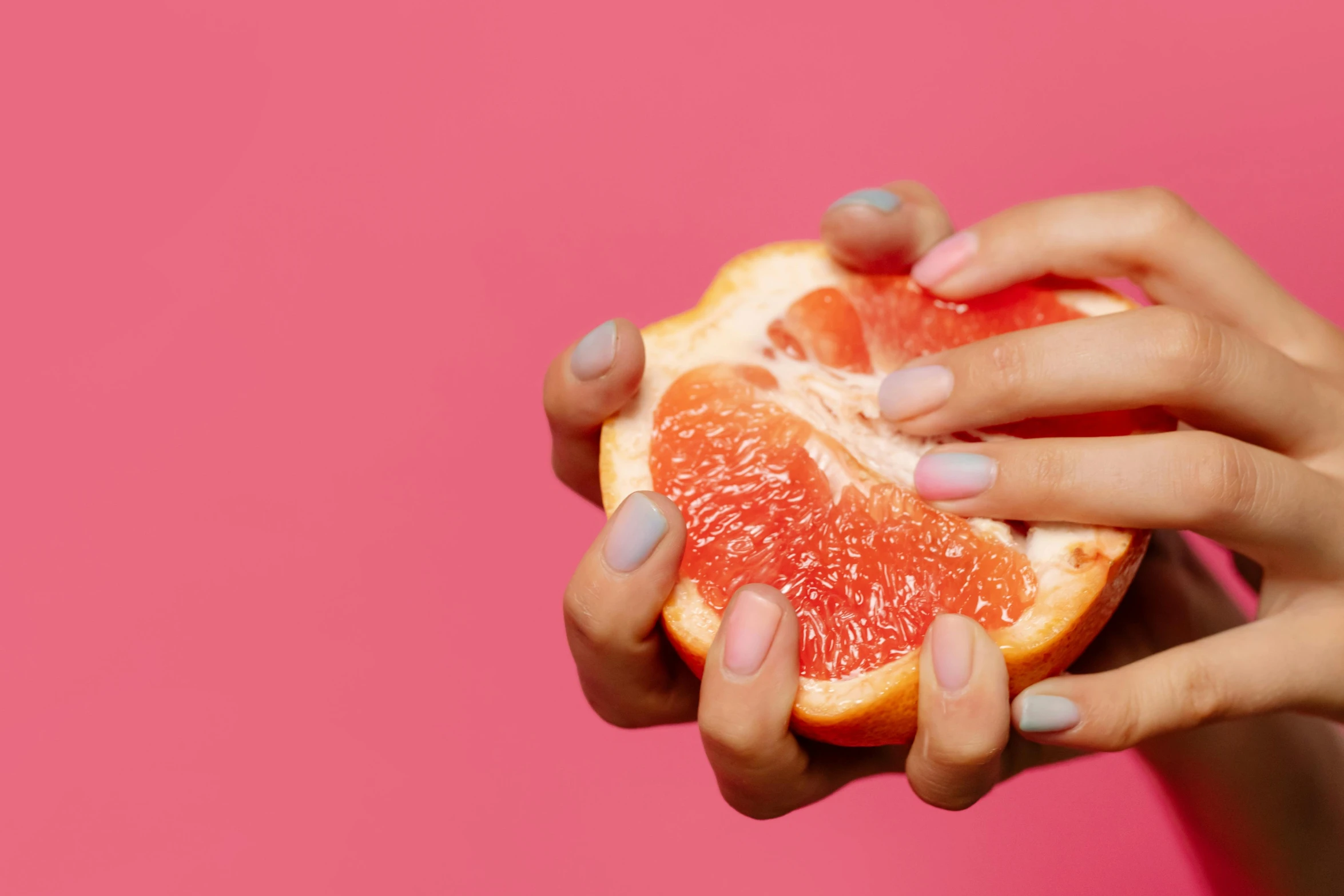 a close up of a person holding a grapefruit, by Julia Pishtar, neat nails, coloured gel studio light, hands not visible, listing image