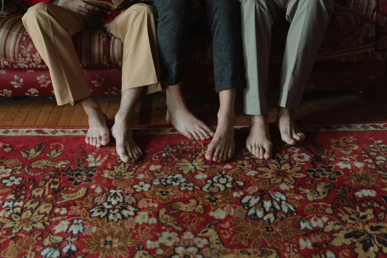 a group of people sitting on top of a couch, by Elsa Bleda, pexels contest winner, hyperrealism, oriental carpets, happy toes, islamic, red and brown color scheme