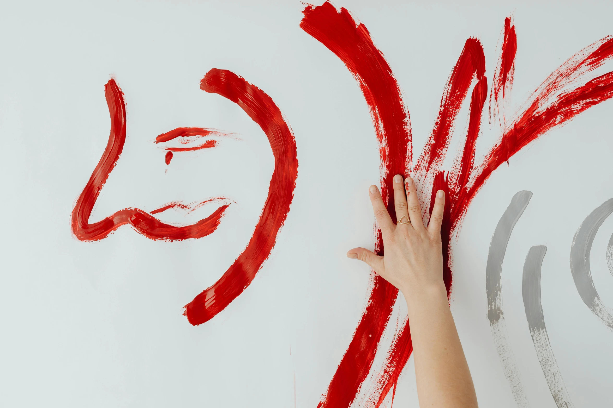 a person drawing on a wall with red paint, inspired by Antoni Tàpies, trending on pexels, with a white background, lesbian art, background image, silver and crimson ink