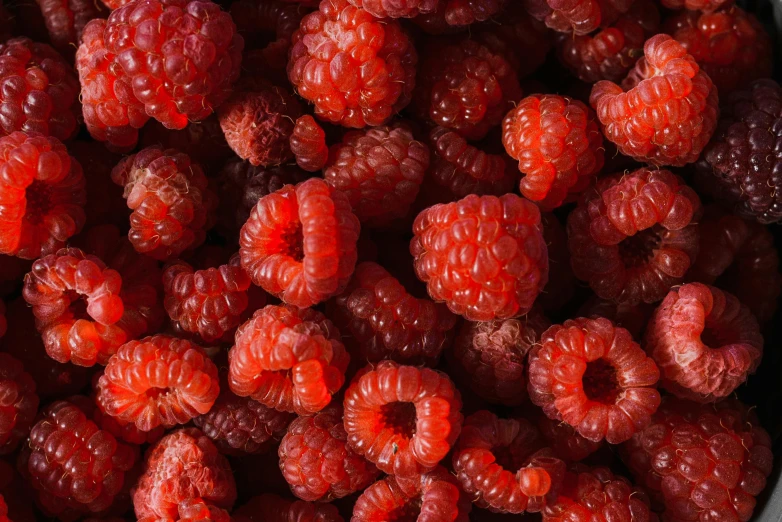 a bowl filled with raspberries sitting on top of a table
