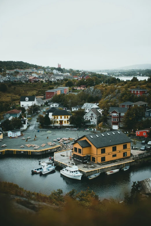 a yellow house sitting on top of a body of water, by Sebastian Spreng, pexels contest winner, docked at harbor, overview, slate, julia hetta