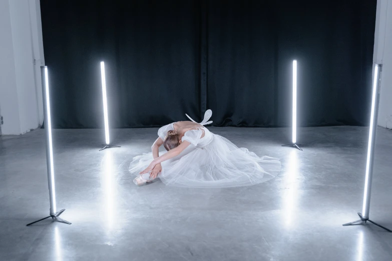 a woman in a white dress laying on the floor, by Elizabeth Polunin, unsplash contest winner, light and space, connected with glowing tubes 8 k, lamp ( ( ( gym ) ) ) ), silver，ivory, floor lamps