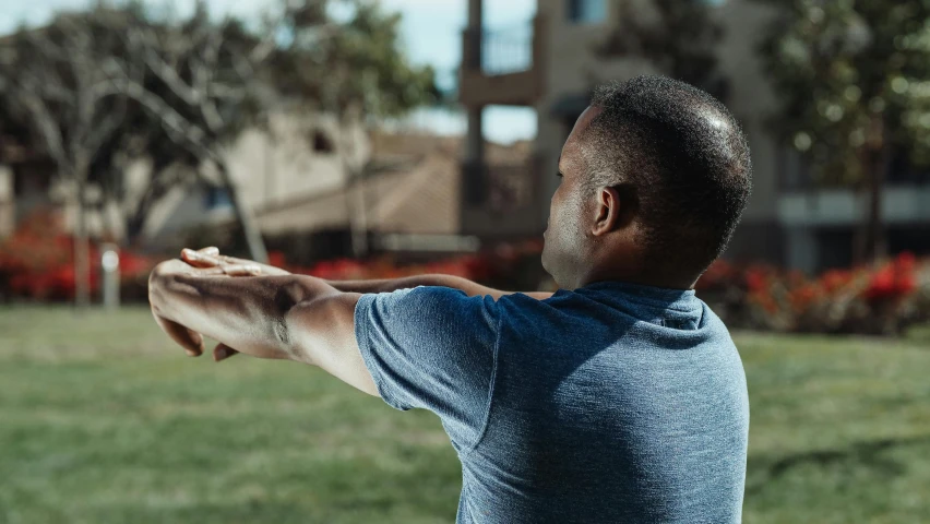 a man throwing a frisbee in a park, a portrait, by Ryan Pancoast, pexels contest winner, happening, insectile forearms folded, heroic shooting bow pose, riyahd cassiem, looking across the shoulder