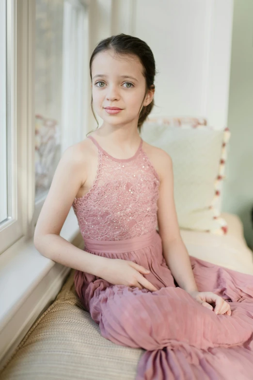 a girl in a pink dress sitting on a window sill, by Ruth Simpson, official product photo, aged 13, long dress, soft textures