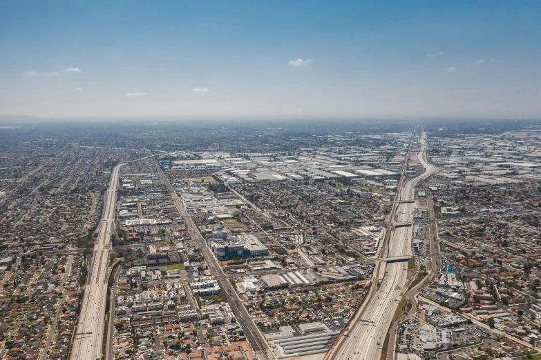 an aerial view of a freeway running through a city, a detailed matte painting, by Ryan Pancoast, unsplash, los angeles 2 0 1 5, landscape of flat wastelands, sky - high view, full daylight