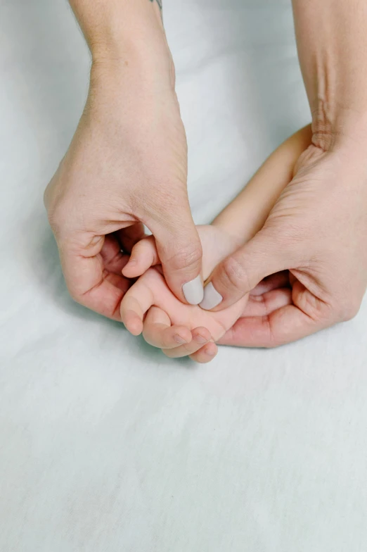 a close up of a person holding something in their hands, by Ruth Simpson, trending on reddit, maternal, japanese, nursing, soft white rubber