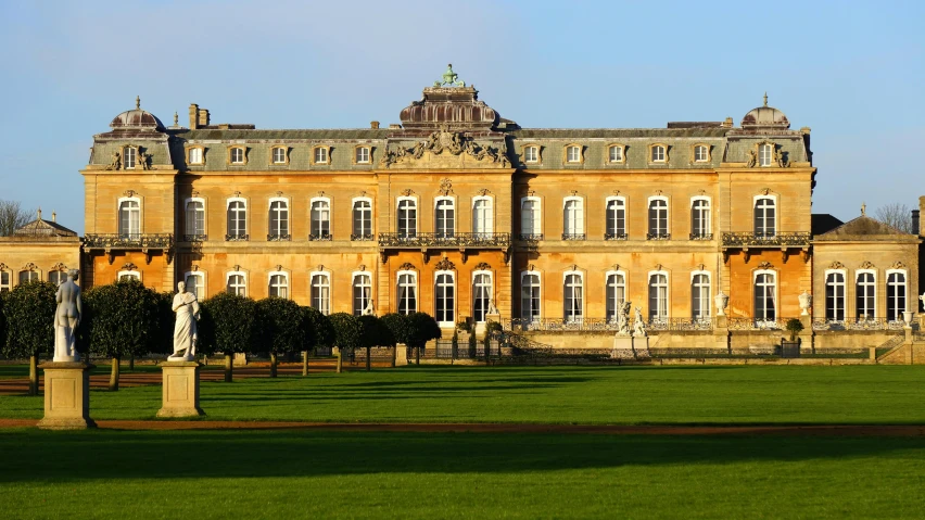 a large building sitting on top of a lush green field, rococo, pink marble building, ochre, from the duchy of lituania, exterior photo