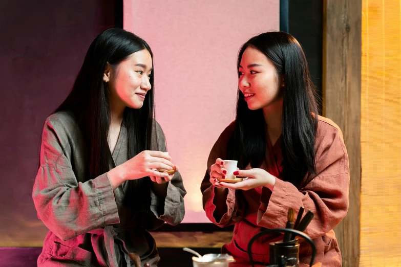 a couple of women standing next to each other, inspired by Wang Duo, trending on pexels, mingei, tea ceremony scene, brown, teamlab, drinks