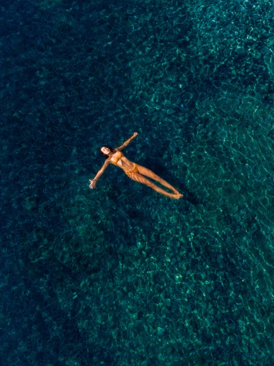 a person floating on top of a body of water, at the sea