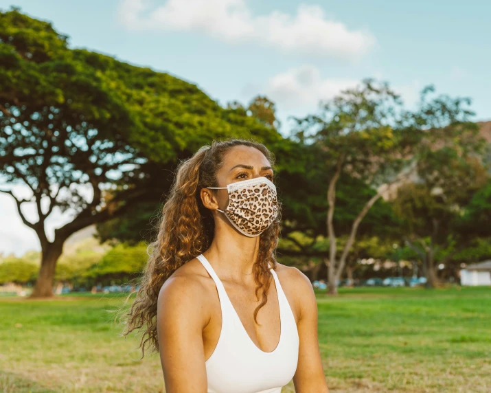 a woman wearing a face mask in a park, trending on pexels, happening, maui, background image, anthro, press shot