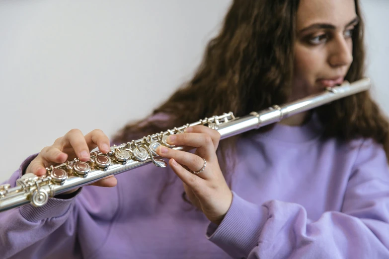 a close up of a person holding a flute, charli bowater, premium, student, shot on 1 5 0 mm