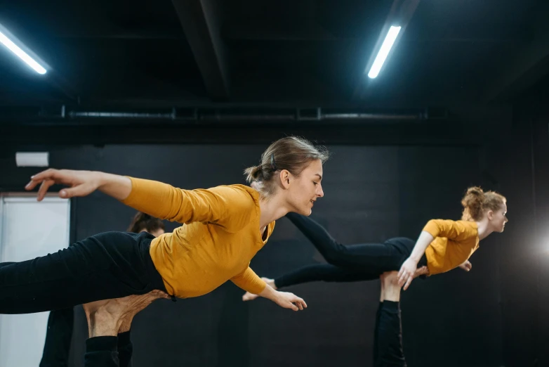 a group of dancers performing in a dance studio, a portrait, by Emma Andijewska, unsplash, arabesque, woman holding another woman, zero gravity, looking partly to the left, anna nikonova aka newmilky