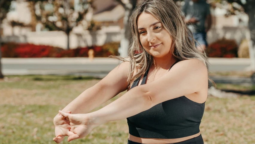 a woman in a black sports bra top throwing a frisbee, trending on pexels, happening, giving a thumbs up, lachlan bailey, wrapped arms, middle eastern skin
