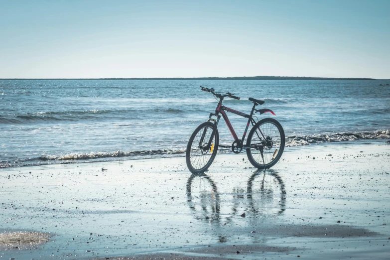 a bicycle parked on a beach next to the ocean, profile image, craigville, on the ocean water, wide views