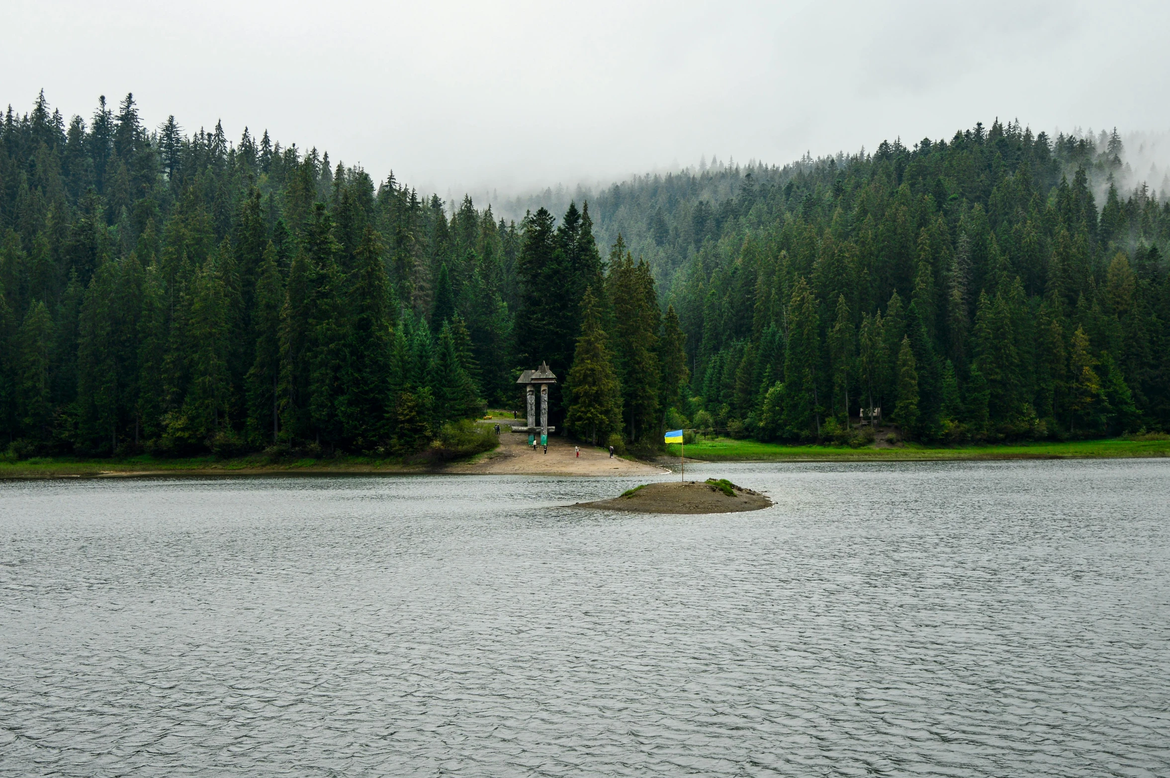 a small island in the middle of a lake, inspired by Avgust Černigoj, pexels contest winner, hurufiyya, sparse pine forest, lookout tower, 2000s photo, whistler