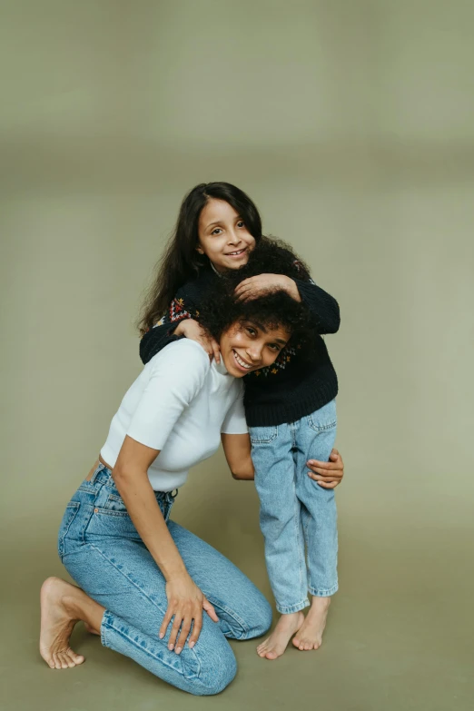 a woman and a child posing for a picture, wearing jeans, promo photo, stacked image, short height