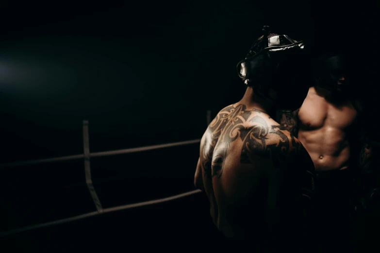 a man with tattoos standing in a boxing ring, pexels contest winner, reylo kissing, warrior fighting in a dark scene, ( ( theatrical ) ), behind the scenes photo