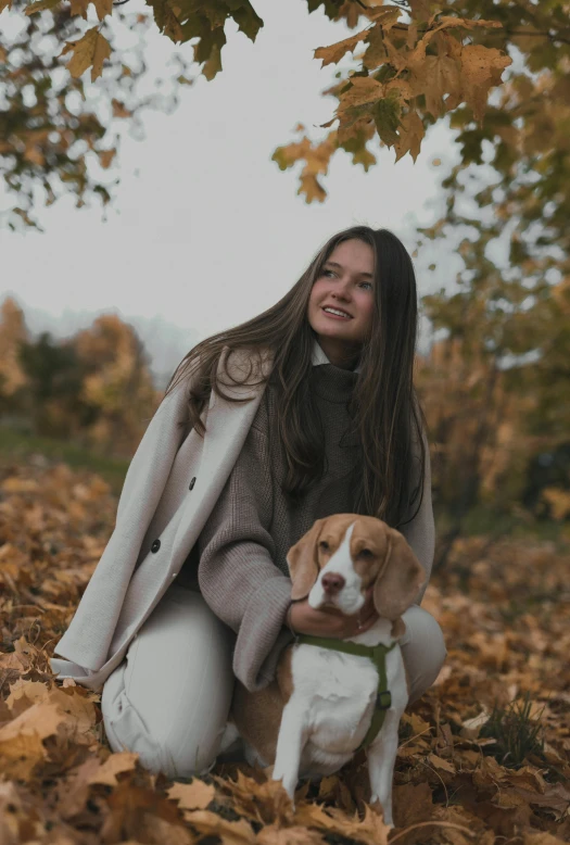 a woman sitting in the leaves with her dog, a picture, brown jacket, trending photo, premium, gif