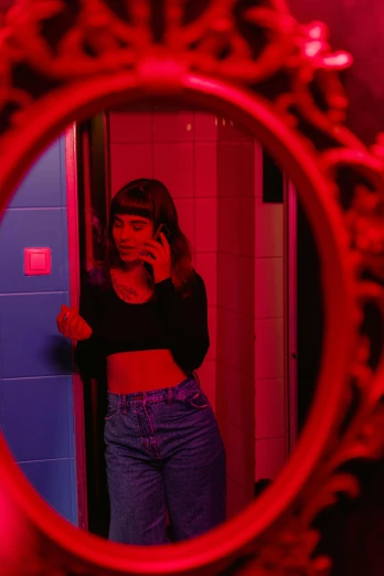 a woman taking a picture of herself in a mirror, inspired by Nan Goldin, trending on pexels, holography, red neon lights, portrait of max caulfield, cinematic outfit photo, red room