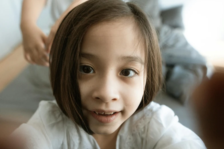 a little girl holding a nintendo wii game controller, inspired by Nara Yoshitomo, pexels contest winner, hurufiyya, asymmetrical haircut, lovingly looking at camera, bedhead, medium close up portrait