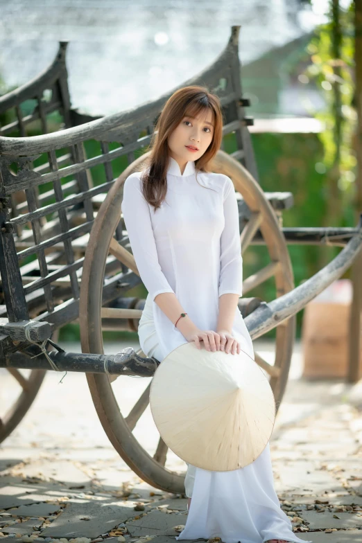 a woman sitting on top of a wooden bench, inspired by Cui Bai, wearing white shirt, vietnamese woman, promotional photo, square