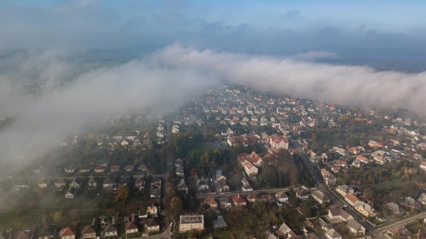 an aerial view of a city on a foggy day, by Petr Brandl, happening, portrait image, high quality image, soft clouds, cinematic shot ar 9:16 -n 6 -g