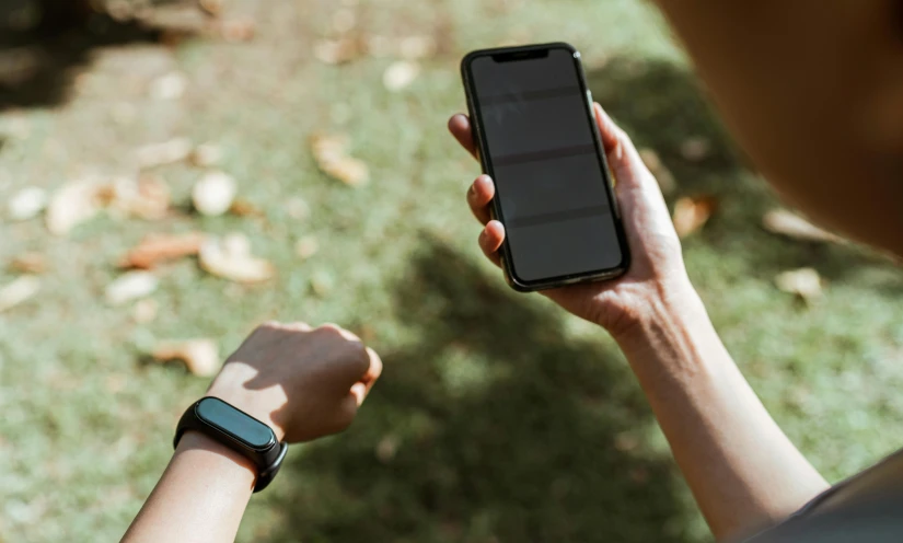 a person holding a smart phone in their hand, by Adam Marczyński, pexels, time travelers appear in a park, game and watch, black bandage on arms, thumbnail