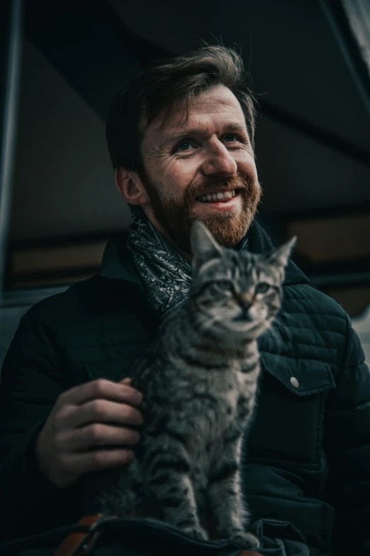 a man sitting in a car with a cat on his lap, by Julia Pishtar, unsplash, both smiling for the camera, felix englund, hr ginger, small beard
