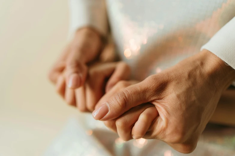 a close up of a person holding a persons hand, glistening body, windings, sitting with wrists together, struggling