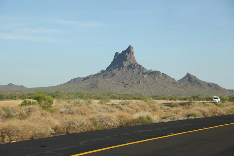 a desert landscape with a mountain in the distance, a picture, highway 5 0, spire, a phoenix, exterior shot