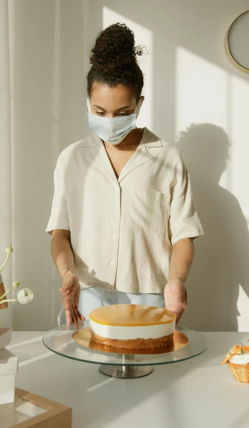 a woman in a face mask decorating a cake, trending on pexels, hyperrealism, wearing a light shirt, modern”, mid shot photo, thumbnail