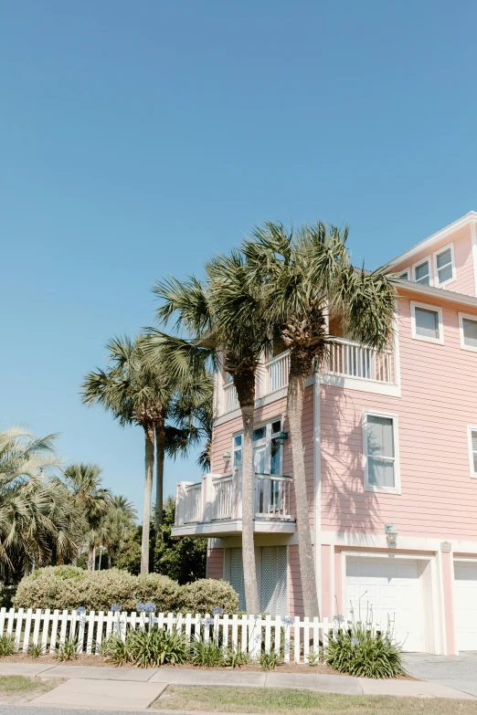 a pink house with palm trees in front of it, by Carey Morris, pexels contest winner, the emerald coast, exterior view, multiple stories, airbnb