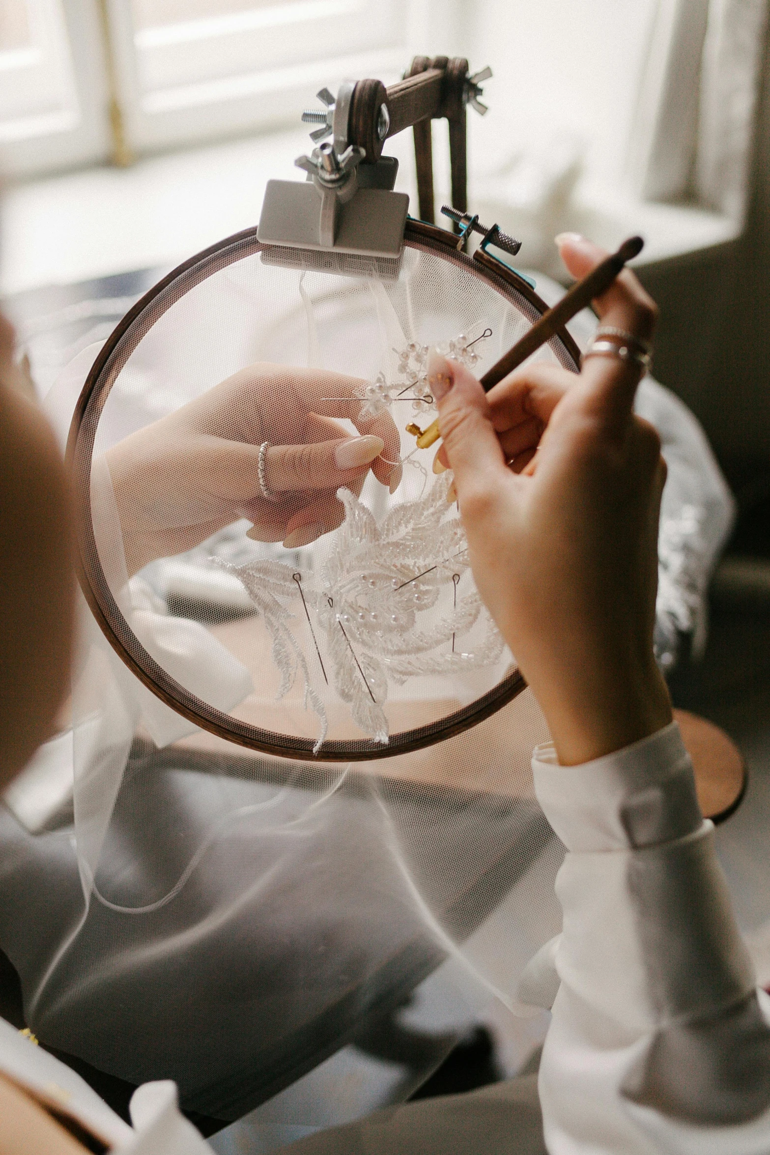 a woman is working on a piece of art, a cross stitch, pexels contest winner, transparent veil, wedding, wearing lab coat and a blouse, swirling