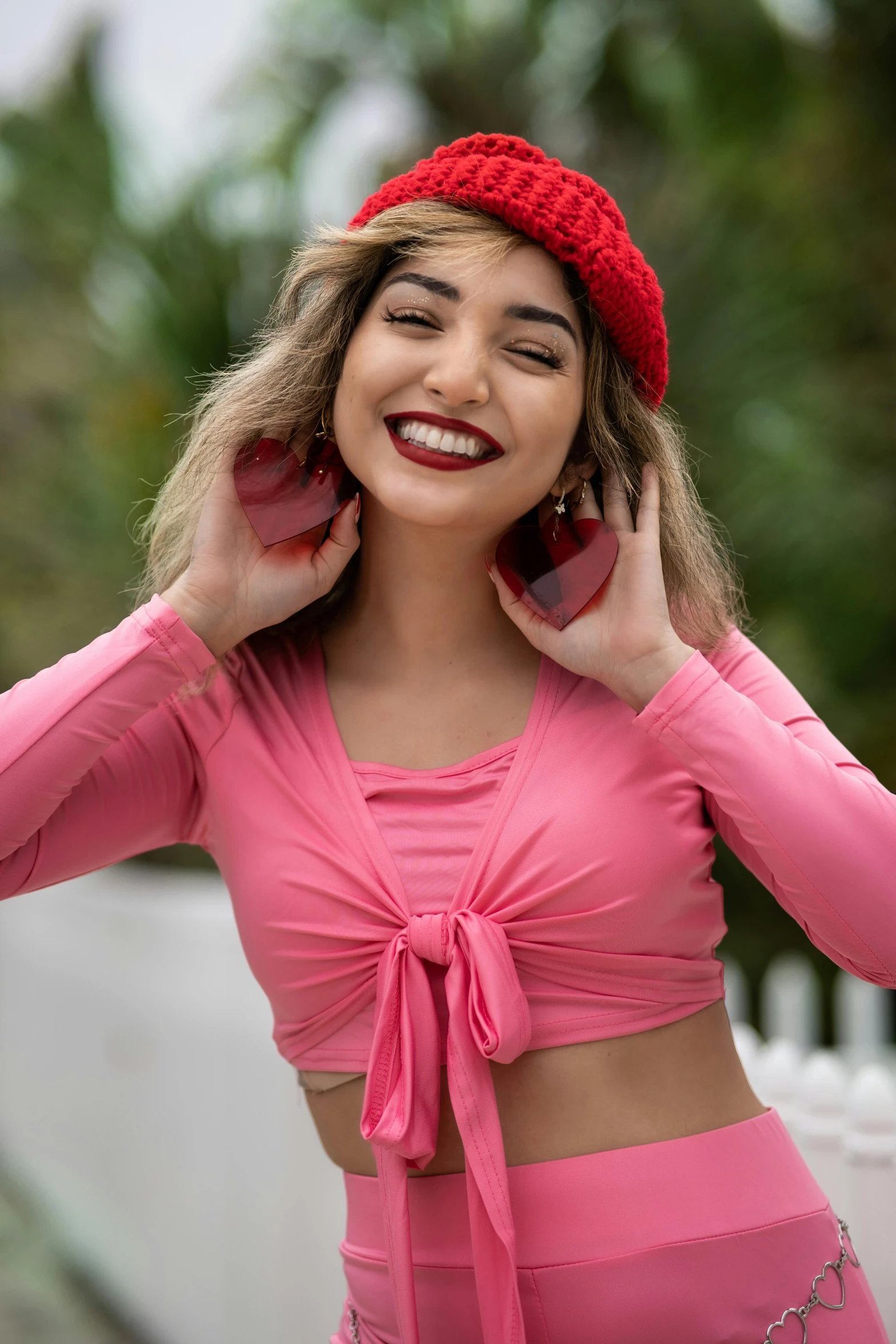 a woman in a pink outfit talking on a cell phone, a portrait, by Everett Warner, trending on pexels, beautiful midriff, red cap, smiling young woman, mia khalifa