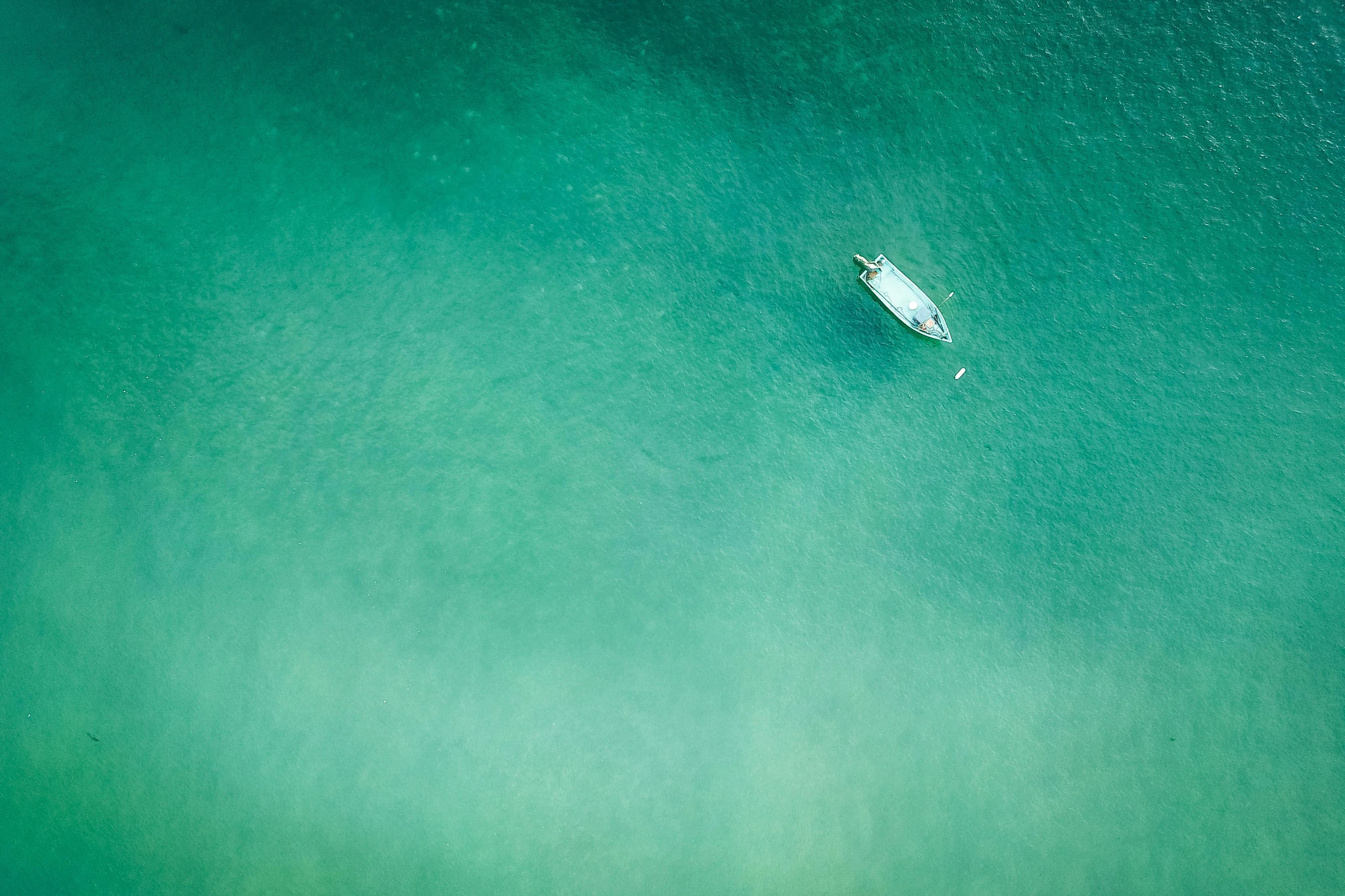 a small boat in the middle of a large body of water, by Peter Churcher, unsplash contest winner, green tones, manly, down there, fisherman