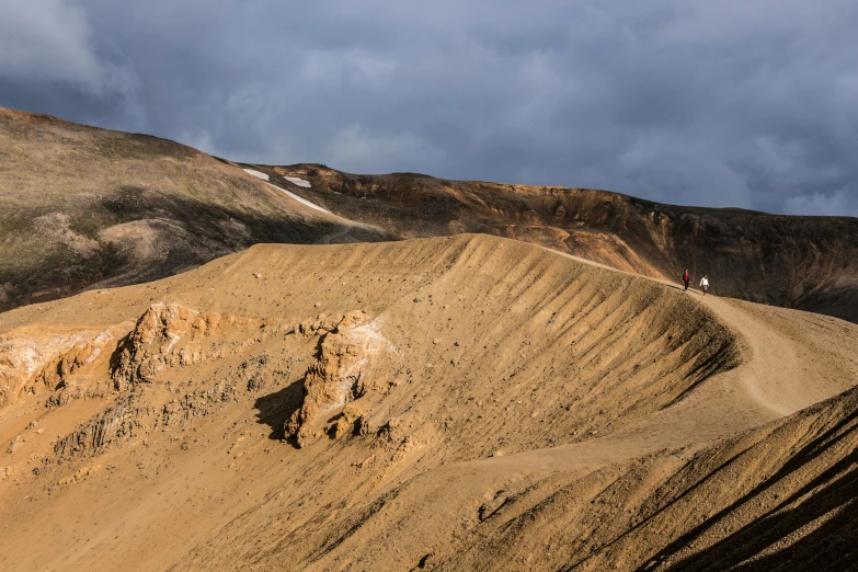 a man riding a motorcycle down a dirt road, by Hallsteinn Sigurðsson, unsplash contest winner, hurufiyya, looking down at a massive crater, ochre, slightly pixelated, brown