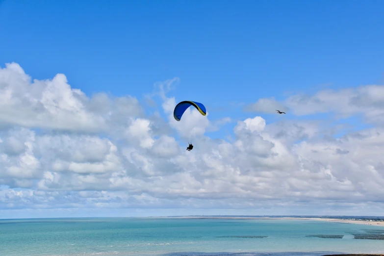 a couple of people on a beach flying a kite, by Peter Churcher, pexels contest winner, hurufiyya, floating. greenish blue, extreme panoramic, parachutes, great barrier reef