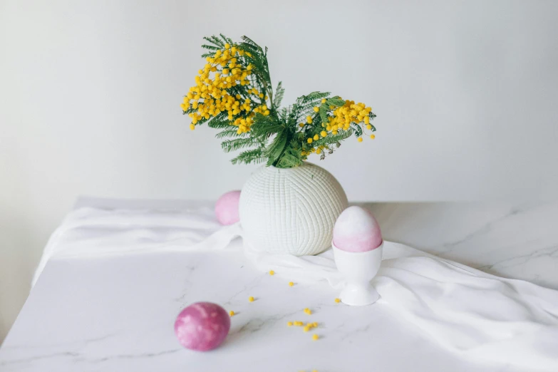 a vase filled with flowers sitting on top of a table, a marble sculpture, inspired by Jeff Koons, unsplash, eggs, pink and yellow, organic ceramic white, festive