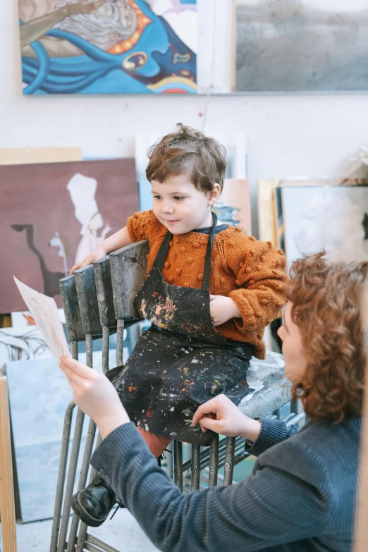 a woman teaching a child how to paint, by Helen Stevenson, pexels contest winner, arbeitsrat für kunst, artist wearing torn overalls, like a catalog photograph, eva elfie, ouchh and and innate studio