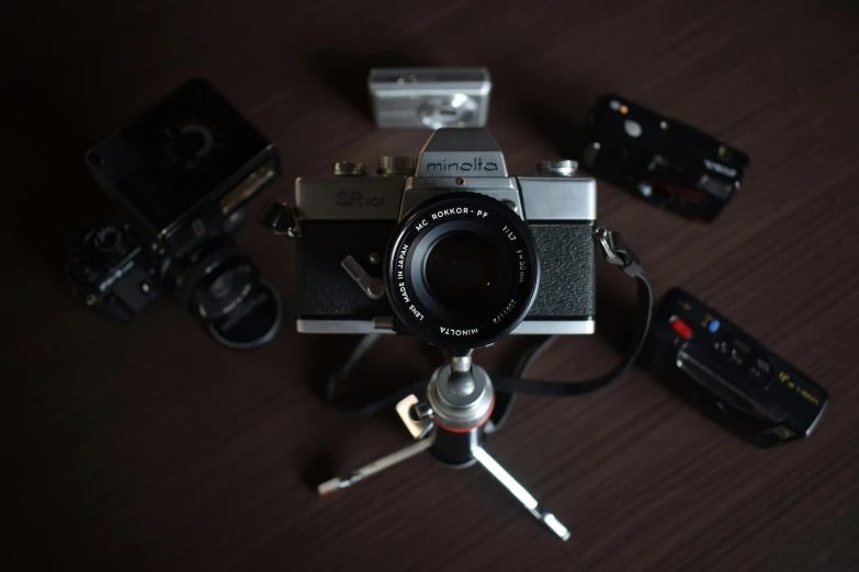 a camera sitting on top of a wooden table, by Mathias Kollros, unsplash, various items, panavision panaflex, analog photo