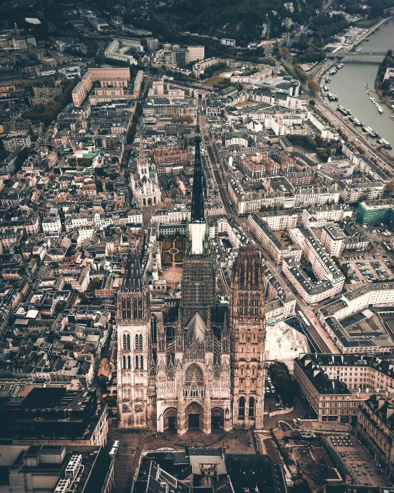 an aerial view of a city with a river in the background, an album cover, by Raphaël Collin, pexels contest winner, renaissance, cathedral!!!!!, brown, exterior, gothic revival