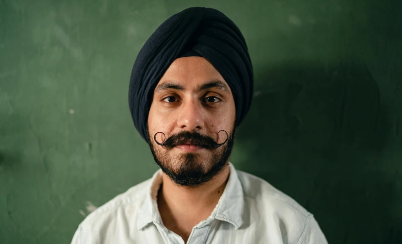 a man with a mustache wearing a turban, by Manjit Bawa, pexels contest winner, wearing a navy blue utility cap, teacher, josh black, slight stubble