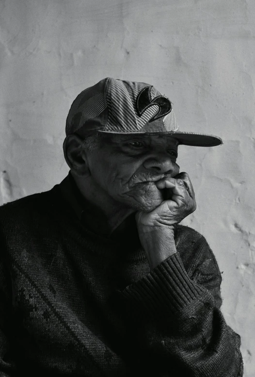 a black and white photo of a man wearing a hat, pexels contest winner, photorealism, samuel jackson, man sitting facing away, wrinkly, profile pic
