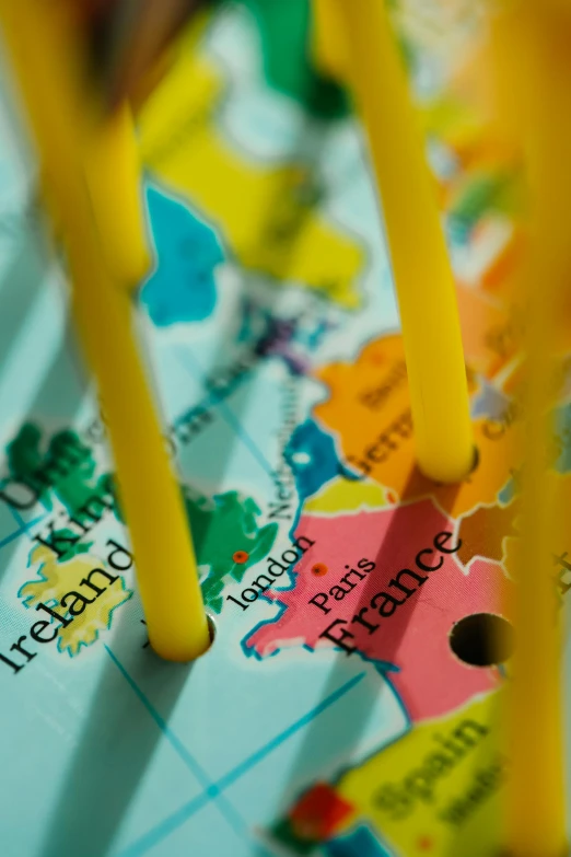 a close up of a map with pins on it, carousel, yellow, educational supplies, french