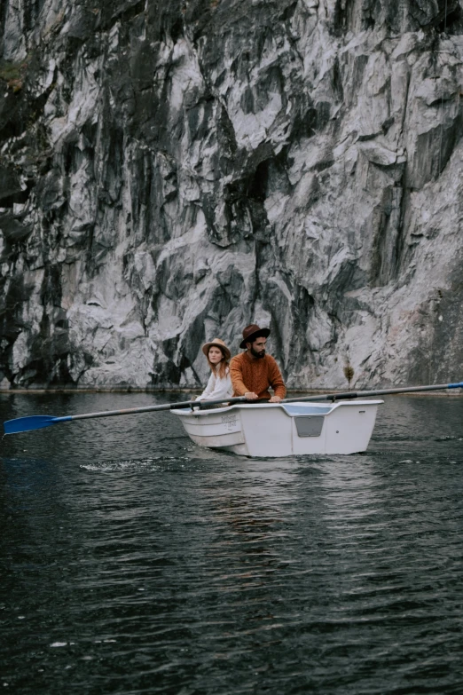 a man and a dog in a boat on a lake, a picture, by Elsa Bleda, unsplash, romanticism, rock quarry location, couple, slate, gray